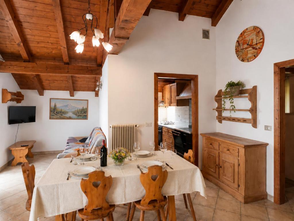 Soggiorno dell'Appartamento ROEN con travi in legno a vista e tavolo da pranzo